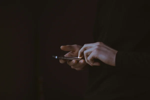 Silhouette einer Person mit einem Smartphone in der Hand