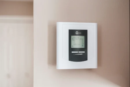 Weißer und grauer Thermostat zeigt 22.5 Grad